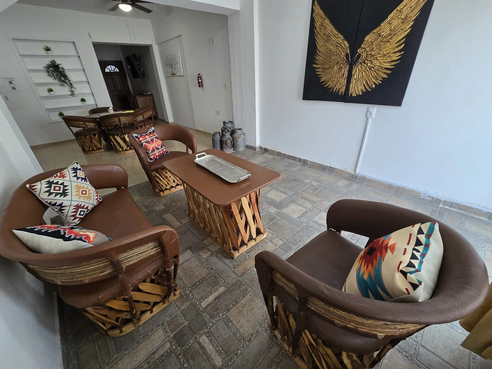 Sala de Casa de los Equipales con sillones artesanales y cojines de colores.